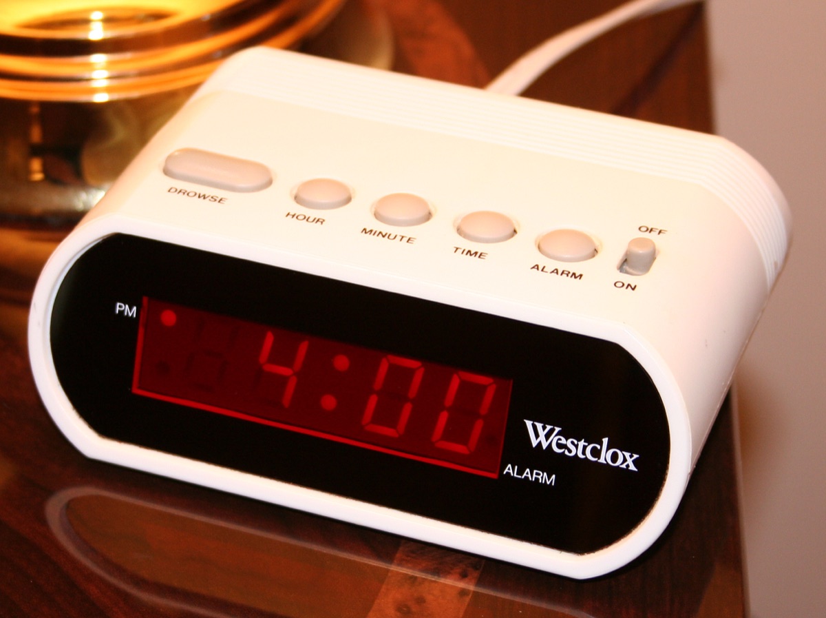 A bedside digital alarm clock, red seven-segment digits