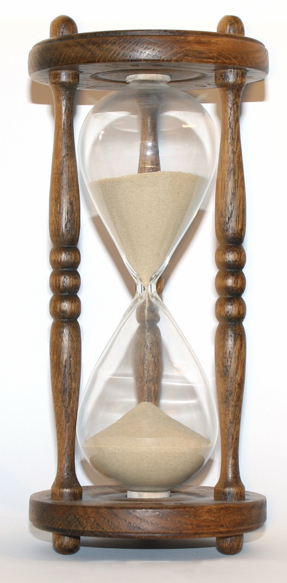 A wooden hourglass, sand mid-fall
